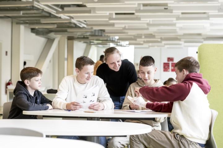 Juf helpt groepje jongens in de eetzaal van Topsportschool Antwerpen.